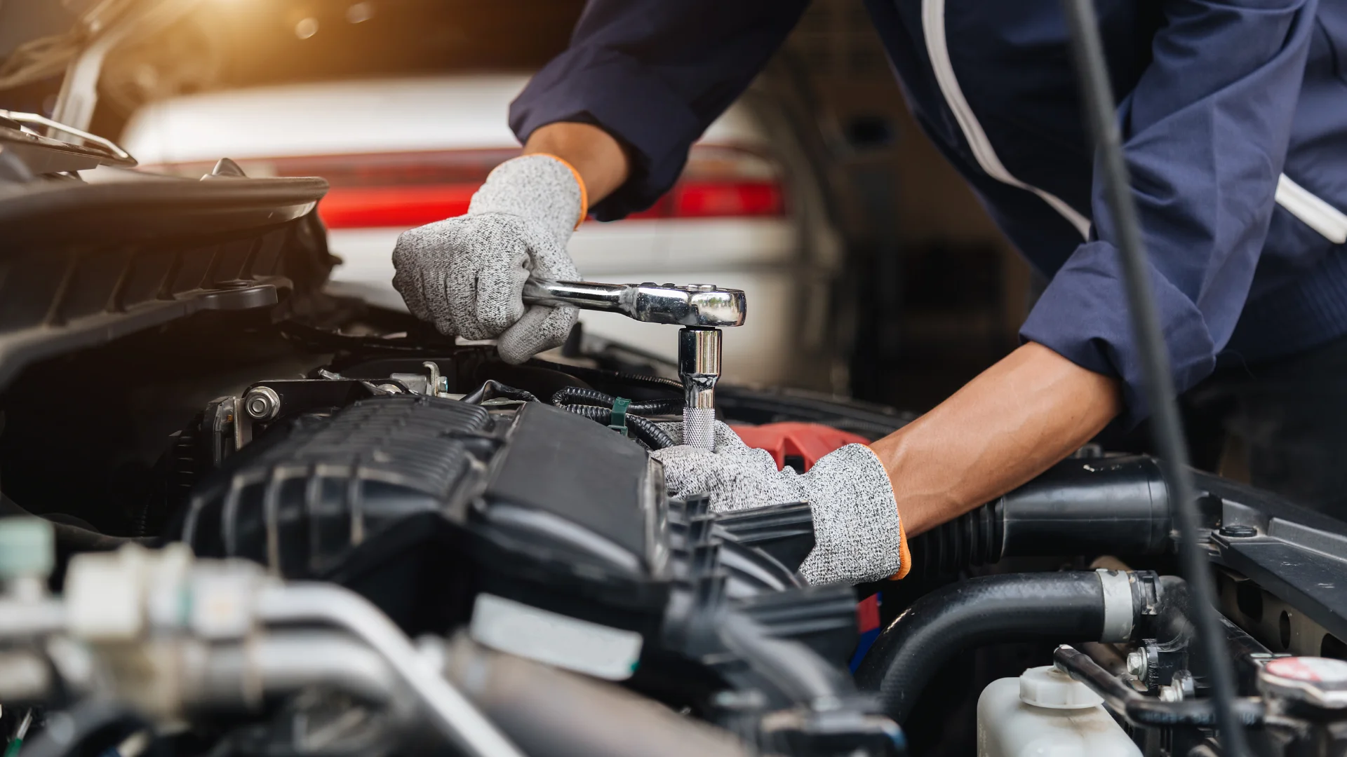 Person with wrench repairing a car